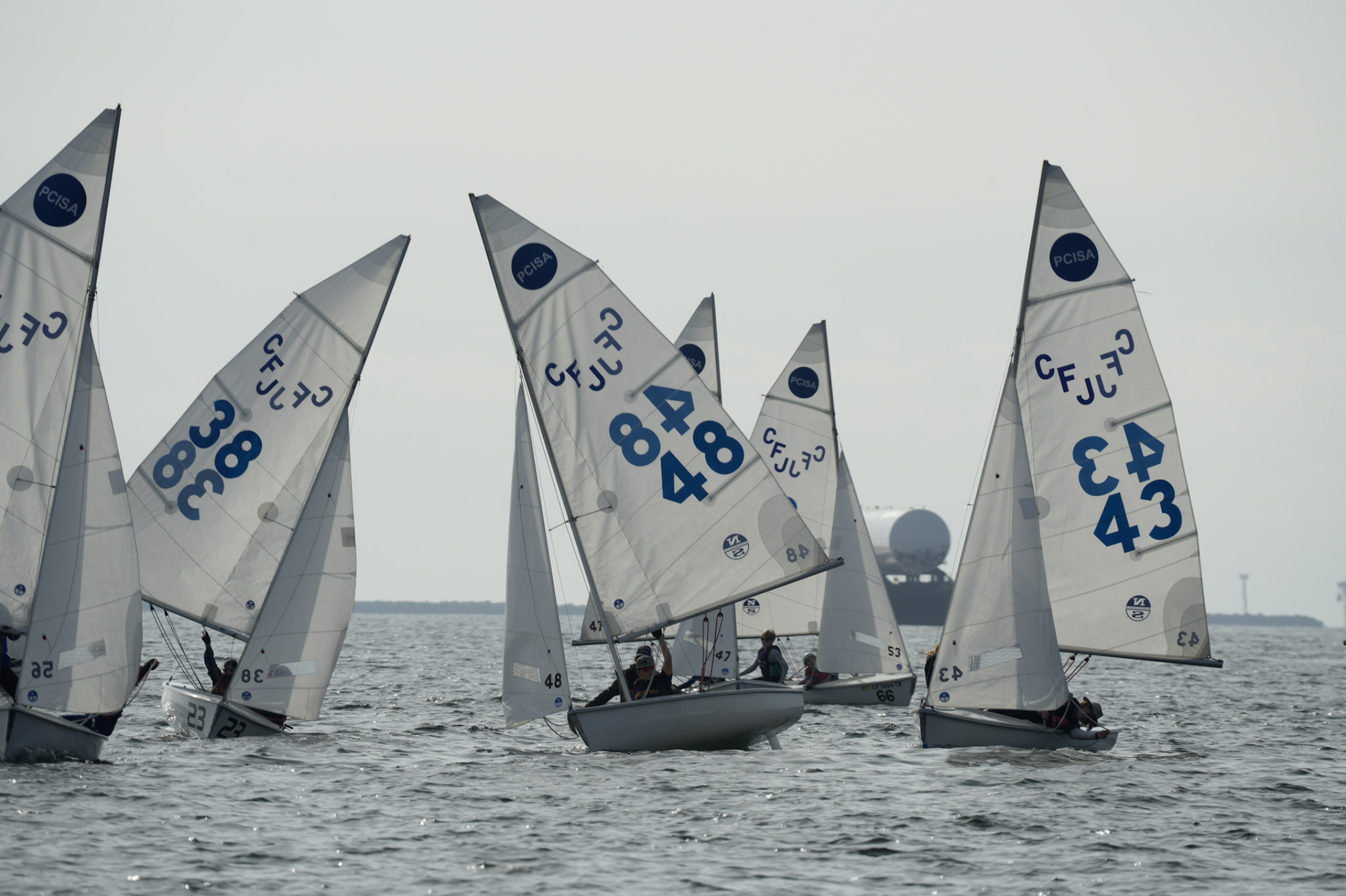 La Jolla High School and Mission Bay High School sailing next to each other downwind during a regatta