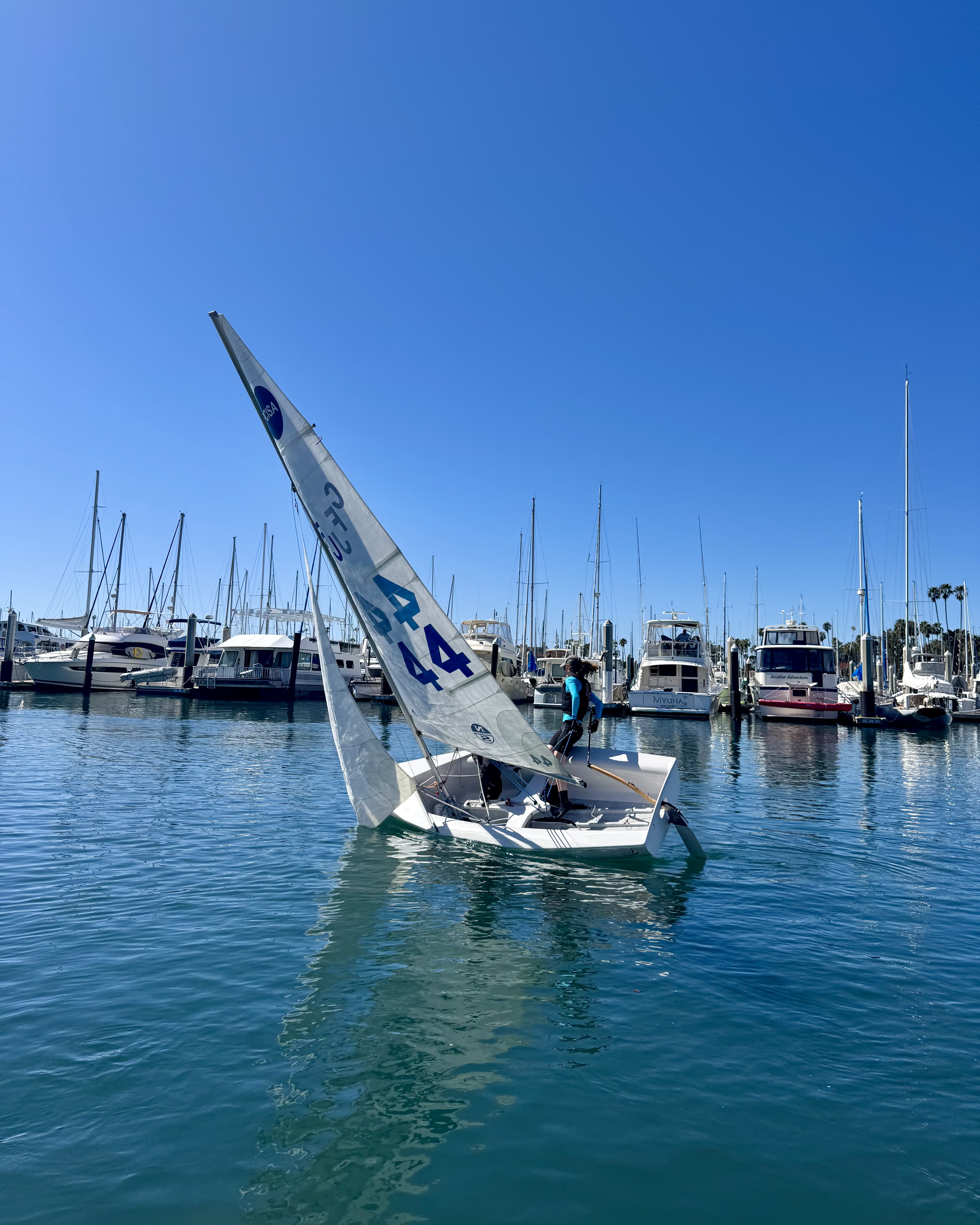 Two La Jolla High School sailors in the middle of a roll tack when there is light wind.